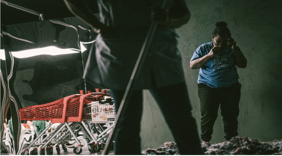 carrello della spesa, due figure umane lavoratrici, toni sul grigio