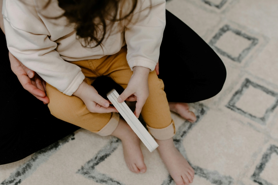 Tappeto da gioco con sopra ragazza e bambino con libro in mano