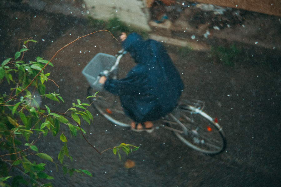 persona sotto la pioggia in bicicletta 