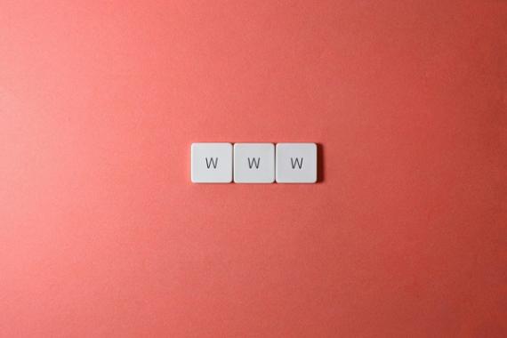sfondo rosa pesca con tre quadratini con scritta una "W" su ognuno, insieme formano la scritta "WWW"
